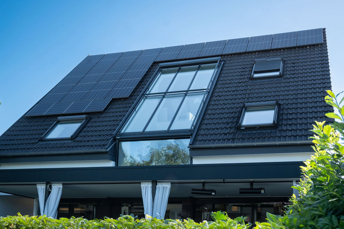Photovoltaikanlage auf dem Schrägdach eines Einfamilienhauses mit großflächigen Solarmodulen und Dachfenstern